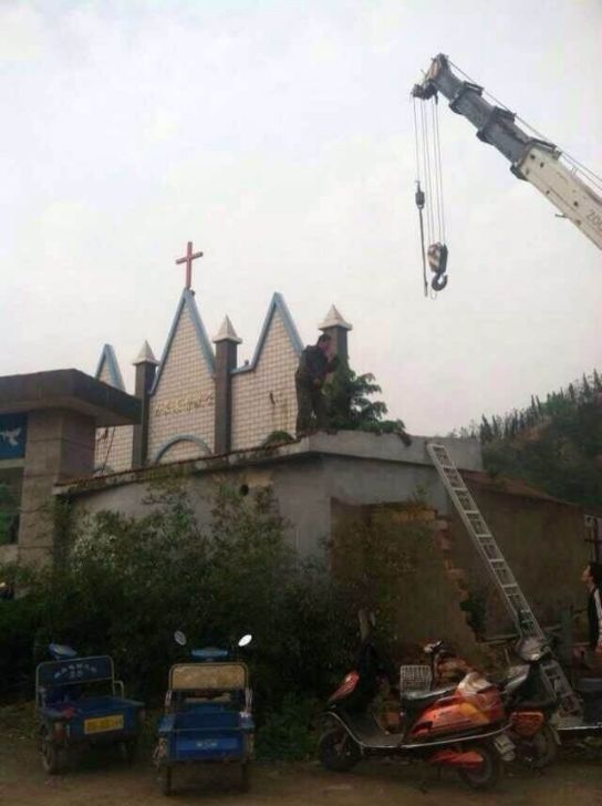 Una gru si appresta a togliere la croce da una chiesa di Zhoushan (Zhejiang)