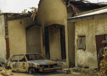 epa04697401 A Nigerian soldier walks amongst a destroyed building and vehicle by Boko Haram Islamic militants after Nigerian troops recaptured Gwoza, Borno State, North East Nigeria 09 April 2015. Following the Nigerian presidential elections Nigerian troops continue to work to contain the wave of attacks by Boko Haram Islamic militants in the North East of Africa's most populous country where Boko Haram have been conducting acts of terror for the past five years.  EPA/STR