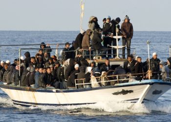 FILE -- In this March 7, 2011 file photo, a boat loaded with migrants is spotted at sea off the Sicilian island of Lampedusa, Italy. The odyssey often begins in an Eritrean refugee camp in Sudan where smugglers offer a deal too good to refuse: Transport to Libya and the chance of a boat trip to Europe, sometimes with no money down. But once in the lawlessness of Libya, the desperate and the dreamers are essentially held hostage by their traffickers until payments are extorted from relatives or they come up with the cash themselves. (AP Photo/Antonello Nusca, File)