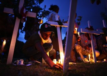 epa04695974 Kenya Red Cross team members light candles among crosses on the ground as they attend the second day of candlelight vigil held for the 148 people killed in an attack on Garissa University College in Garissa town, in downtown Nairobi, Kenya, 08 April 2015. Hundreds of Kenyans continue to gather in solidarity to mourn the loss of their countrymen while five terror suspects were arraigned in a Nairobi court on 07 April for supplying attackers with guns used in an attack. Kenyan government on 08 April froze 85 bank accounts linked to suspected supporters of al-Shabab.  EPA/DANIEL IRUNGU