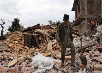 epa04726837 A man walks through the rubble of a destroyed building in the village of Sankhuckhock Sukute, 70  kilometers from Kathmandu, Nepal, 30 April 2015. The official death toll from the magnitude 7.8 earthquake 25 April has risen to 5057 people according to the National Emergency Operation Centre, while thousands more have been left homeless.  EPA/SEDAT SUNA