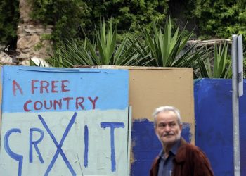 A man passes graffiti in the Plaka tourist district in Athens, on Tuesday, May, 12, 2015. Greece may have only a couple of weeks left before it faces real problems meeting its financial commitments, the country's finance minister conceded Monday as talks with European creditors dragged on without agreement. (AP Photo/Thanassis Stavrakis)