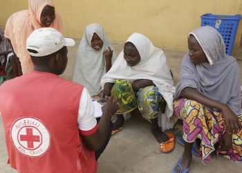 A Red Cross official takes data from women and children rescued by Nigerian soldiers from Boko Haram extremists at Sambisa Forest rest at a refugee camp in Yola, Nigeria Monday, May 4, 2015. Even with the crackle of gunfire signaling rescuers were near, the horrors did not end: Boko Haram fighters stoned captives to death, some girls and women were crushed by an armored car and three died when a land mine exploded as they walked to freedom.  (AP Photo/Sunday Alamba)