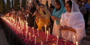 Pakistani lawmakers light candles and pray for the victims of a bus attack in Karachi, Pakistan, Thursday, May 14, 2015. Amid tight security, hundreds of Pakistanis Thursday paid their respects at a mass funeral for 45 minority Shiites who were killed in an attack on a bus in the southern city of Karachi. (AP Photo/Shakil Adil)