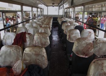 People look at a bus with blood-stained seats targeted by attackers in Karachi, Pakistan, Wednesday, May 13, 2015. Gunmen stormed the bus in southern Pakistan and ordered its Shiite Muslim passengers to bow their heads before shooting them, killing dozens of people in the latest attack targeting religious minority, officials said. (AP Photo/Tariq Saleem)