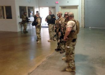 Members of the Garland Police Department are stand inside the Curtis Culwell Center on Sunday, May 3, 2015, in Garland, Texas. A contest for cartoons depictions of the Prophet Muhammad in the Dallas suburb is on lockdown Sunday after authorities reported a shooting outside the building. (AP Photo Nomaan Merchant)