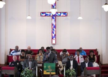 Pastor Mark Washington leads a prayer during a vigil to mourn the lives lost at the shooting in Charleston, S.C., Friday, June 19, 2015, at Metropolitan AME Church in Austin, Texas. Dylann Roof is a suspect in the shooting was ordered held until a bond is set on murder charges. (Dborah Cannon/Austin American-Statesman via AP)  AUSTIN CHRONICLE OUT, COMMUNITY IMPACT OUT, INTERNET AND TV MUST CREDIT PHOTOGRAPHER AND STATESMAN.COM, MAGS OUT
