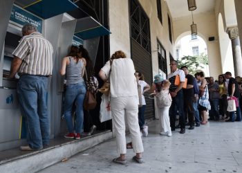 People line up at ATMs outside a National bank branch in the northern Greek port city of Thessaloniki, Monday, June 29, 2015.  Anxious Greeks lined up at ATMs as they gradually began dispensing cash again on the first day of capital controls imposed in a dramatic twist in Greece’s five-year financial saga. Banks will remain shut until next Monday, and a daily limit of 60 euros ($67) has been placed on cash withdrawals from ATMs . (AP Photo/Giannis Papanikos)