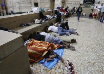 Migrants rest and sleep at Milan's main train station, Italy, early Friday morning, June 12, 2015. Milan city officials have appealed for help in managing the huge flow of migrants arriving from southern Italy after rescue at sea, as increasing numbers are unable to find beds and are sleeping in the train station. (AP Photo/Luca Bruno)