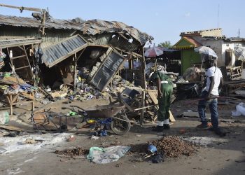 People gather at the site of a suicide bomb attack at a market in Maiduguri, Nigeria, Monday June 22, 2015. Two girls blew themselves up on Monday near a crowded mosque in northeast Nigeria's biggest city, killing about 30 people, witnesses said. It is the fourth suicide bombing this month in Maiduguri, which is the birthplace of the Boko Haram Islamic extremist group. (AP Photo/Jossy Ola)