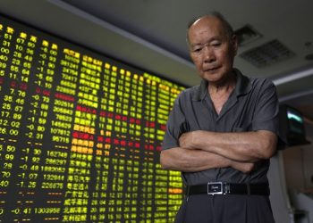 A man walks past an electric board displaying stock prices at a brokerage house in Hangzhou in east China's Zhejiang province Monda,y July 27, 2015. The Shanghai share index dived more than 8 percent Monday as Chinese stocks suffered a renewed sell-off despite government efforts to calm the market. Monday's fall on the Shanghai market was the biggest one-day decline in Chinese stocks since an 8.8 percent plunge on Feb. 27, 2007, according to financial data provider FactSet. (Chinatopix via AP) CHINA OUT