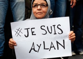 A woman holds a placard reading "I am Aylan", referencing the  3-year-old boy found lifeless on a beach of Kos island, Greece, during a gathering to support migrants, in Paris, Saturday, Sept. 5, 2015.  Thousands have filled a Paris square in support of the migrants, waving flags in solidarity. One man held up a sign saying: "We are all descendants of immigrants." French public opinion has been divided over how to handle the growing demands for asylum by people fleeing war and poverty. (AP Photo/Thibault Camus)
