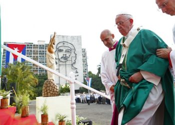 Pope Francis is helped to the altar as he arrives to celebrate Mass in Revolution Square in Havana, Cuba, Sunday, Sept. 20, 2015, where a sculpture of revolutionary hero Ernesto "Che" Guevara decorates a nearby government building. Pope Francis opens his first full day in Cuba on Sunday with what normally would be the culminating highlight of a papal visit: Mass before hundreds of thousands of people in Havana's Revolution Plaza.  (Tony Gentile/POOL via AP)