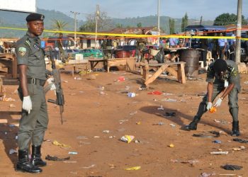 Police collect items at the site of a bomb explosion in Nyanya outskirt of Abuja, Nigeria, Saturday, Oct. 3, 2015.  Multiple bombs detonated in two locations killing at least 15 people, the National Emergency Management Agency said Saturday, although no group has claimed responsibility the attack has attributes of others by Boko Haram, the home-grown Islamic extremist group.(AP Photo/Gbenga Olamikan)