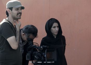 In this undated photo made available Wednesday, Oct. 14, 2015, by film director Keywan Karimi, director Karimi, from left, cameraman Arasto Givi and assistant director Fateme Hafezi work on a scene of the movie called "Writing on the City" in Tehran, Iran. The award-winning Iranian filmmaker whose work focuses on the travails of modern life and political expression in the Islamic Republic has been sentenced to six years in prison over his movies. (Sajad Vasiresh via AP)