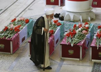 Senior Iranian cleric Ayatollah Ahmad Jannati, secretary of the Guardian Council, Iran's constitutional watchdog, walks past coffins of pilgrims who were killed in a stampede during the hajj pilgrimage in Saudi Arabia last month, during a funeral ceremony attended by thousands of mourners at Tehran University campus, Tehran, Iran, Sunday, Oct. 4, 2015. Iran has blamed Saudi authorities for the disaster, which heightened tensions between the two regional rivals. Saudi authorities say 769 pilgrims died in the stampede near Mecca in the worst disaster to strike the annual pilgrimage in a quarter-century. Iran appears to have lost the largest number of pilgrims, with 464 dead. (AP Photo/Vahid Salemi)