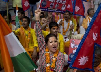 A Nepali woman shouts slogans during a protest against Nepal's government and demanding it be restored as a Hindu nation, in New Delhi, India, Tuesday, Sept. 22, 2015. Nepal says protests against its new constitution formally adopted on Sept. 20, 2015, are abating, just hours after police opened fire on a crowd and injured three in the east of the Himalayan nation. (AP Photo/Tsering Topgyal)