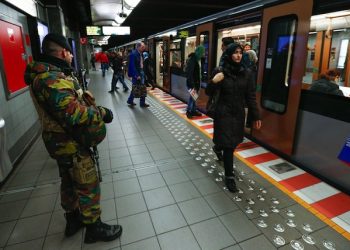 epa05040858 A Belgian soldiers observes the platform of a Brussels' metro station following the terror alert level being raised to 4/4, in Brussels, Belgium, 25 November 2015. Regular life began to return to Brussels on 25 November as schools reopened and underground train services partially resumed, despite the city remaining under maximum terrorism alert in the wake of the November 13 attacks on Paris. The Belgian capital has been under security alert level four since 21 November, due to what Belgian Prime Minister Charles Michel described as a 'serious and imminent threat.'  EPA/LAURENT DUBRULE