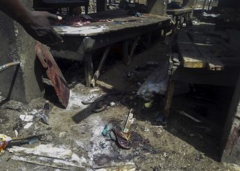 epa04780579 A Nigerian man points to sandals at the scene of a bomb blast at the abattoir, in Maiduguri, Nigeria 02 June 2015. Dozens of people were feared dead after a bomb blast ripped through the crowded marketplace in the north-eastern Nigerian city. The attack is though to be the work Islamic militant group Boko Haram. Maiduguiri was the scene of a suicide bomb blast in a Mosque over the weekend. Boko Haram, which seeks to establish a state with its very strict interpretation of Islamic law, has killed more than 14,000 people since 2009.  EPA/STR ATTENTION EDITORS: PICTURE CONTAINS GRAPHIC CONTENT