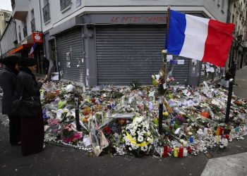 epa05035825 People gather in front of the memorial set near the Le Petit Cambodge restaurant to mark a week since the start of the terrorist attacks, in Paris, France, 21 November 2015. More than 130 people were killed and hundreds injured in the terror attacks which targeted the Bataclan concert hall, the Stade de France national sports stadium, and several restaurants and bars in the French capital on 13 November.  EPA/SEBASTIEN NOGIER