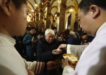 epa03517391 Chinese Catholics receive the communion bread in the Xuanwumen Catholic Church during a Christmas Eve mass in Beijing, China 24 December 2012. Christians in China attend church masses as they prepare to celebrate the religious holiday to commemorate the birth of Christ.  EPA/HOW HWEE YOUNG