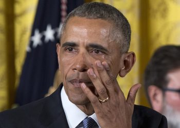 President Barack Obama wipes away tears from his eyes as he speaks in the East Room of the White House in Washington, Tuesday, Jan. 5, 2016, about steps his administration is taking to reduce gun violence. Also on stage are stakeholders, and individuals whose lives have been impacted by the gun violence. (AP Photo/Carolyn Kaster)