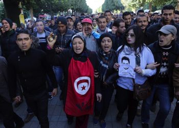 epa05116260 Unemployed graduates shout slogans during a demonstration urging the government to provide them with job opportunities, in Tunis, Tunisia, 21 January 2016. Reports state one policeman was killed in clashes between security forces and protesters demanding jobs in Tunisia's western-central province of Kasserine, a security official said on 21 January. The protests in Kasserine started at the weekend after an unemployed young man reportedly suffered a deadly electric shock when he climbed a power pole to protest a rejected job application.  EPA/MOHAMED MESSARA