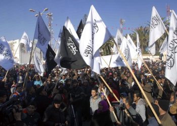 epa03995080 A photograph made available on 18 December 2013 shows Tunisian protesters waving the black and white flags used by Islamists during a protest to mark the third anniversary of the revolution, in Sidi Bouzid, Tunisia, 17 December 2013. Young fruit vendor, Mohamed Bouazizi, set himself ablaze on 17 December 2010 in the Tunisian town of Sidi Bouzid, sparking a nation-wide uprising that led 28 days later to the ousting of President Zine Al Abidine Ben Ali, and later to regional revolutions of the so-called Arab Spring.  EPA/STR