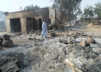 A man walks past burnt out houses following an attack by Boko Haram in Dalori village 5 kilometers (3 miles) from Maiduguri, Nigeria, Sunday Jan. 31, 2016. A survivor hidden in a tree says he watched Boko Haram extremists firebomb huts and listened to the screams of children among people burned to death in the latest attack by Nigeriaí s homegrown Islamic extremists. (AP Photo/Jossy Ola)