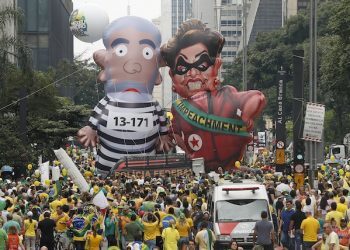Demonstrators parade large inflatable dolls depicting Brazil's former President Luiz Inacio Lula da Silva in prison garb and current President Dilma Rousseff dressed as a thief, with a presidential sash that reads "Impeachment," in Sao Paulo, Brazil, Sunday, March 13, 2016. The corruption scandal at the state-run oil giant Petrobras has ensnared key figures from Rousseff’s Workers’ Party, including her predecessor and mentor, Lula da Silva, as well as members of opposition parties. (AP Photo/Andre Penner)