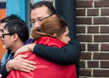 People comfort each other after being evacuated from Brussels airport, after explosions rocked the facility in Brussels, Belgium, Tuesday March 22, 2016. Authorities locked down the Belgian capital on Tuesday after explosions rocked the Brussels airport and subway system, killing at least 13 people and injuring many more. Belgium raised its terror alert to its highest level, diverting arriving planes and trains and ordering people to stay where they were. Airports across Europe tightened security. (AP Photo/Geert Vanden Wijngaert)