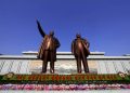 Flowers are laid under bronze statues of North Korea's late leaders Kim Il Sung, left, and Kim Jong Il at Mansu Hill in Pyongyang, North Korea, Friday, April 15, 2016, to commemorate North founder Kim Il Sung's birthday. The banner reads: "Great comrades Kim Il Sung and Kim Jong Il are with us eternally." (AP Photo/Kim Gwang Hyon)