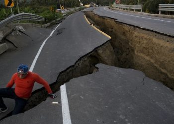 A man jokes around after taking some pictures of a section of highway that collapsed due to a 7.8-magnitude earthquake, in Chacras, Ecuador, Tuesday, April 19, 2016. The strongest earthquake to hit Ecuador in decades flattened buildings and buckled highways along its Pacific coast, sending the Andean nation into a state of emergency. (AP Photo/Rodrigo Abd)