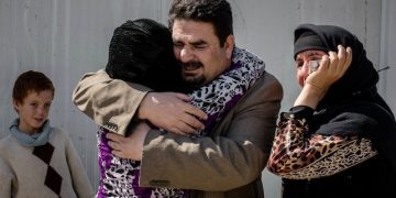 In this Thursday, March 31, 2016 photo, Balkis, 15, embraces her father, Sheikh Matar, after being separated from him for over a year. Balkis stayed with her mother, younger sister, and two younger brothers in Islamic State group controlled territory after her father was forced to flee to the Kurdish north. They were able to come together when recent fighting between Iraqi forces and IS created an opportunity for them to escape late the previous night. (AP Photo/Cengiz Yar)