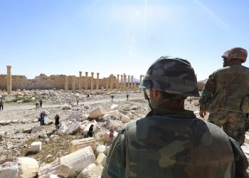 In this picture taken Friday, April 1, 2016, soldiers look over damage at the historical Bel Temple in the ancient city of Palmyra in the central city of Homs, Syria. Explosions rocked the ancient town of Palmyra on Friday and on the horizon, black smoke wafted behind its majestic Roman ruins, as Syrian army experts carefully detonated hundreds of mines they say were planted by Islamic State militants before they fled the town. (AP Photo)