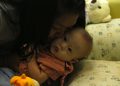 epa04340353 A Thai surrogate mother, Pattharamon Janbua, 21, kisses her seven-month-old Down's Syndrome baby, Gammy or Naruebet Mincharoen at a hospital in Chonburi province, Thailand, 04 August 2014. The Australian father of a baby with Down's syndrome born to a surrogate in Thailand has denied abandoning the child while taking home his healthy twin sister. Gammy is one of twins born to Thai woman Pattharamon Janbua who said she was paid by the unidentified Australian couple to deliver an in vitro fertilized baby. The case sparked a public outcry and put a spotlight on transnational commercial surrogacy laws in Thailand and Australia.  EPA/RUNGROJ YONGRIT