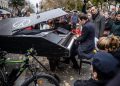 epa05028435 Pianist Davide Martello plays the  Lennon's song Imagine in front of the memorial set near the Bataclan concert venue in Paris, France, 16 November 2015. More than 130 people were killed and hundreds injured in the terror attacks which targeted the Bataclan concert hall, the Stade de France national sports stadium, and several restaurants and bars in the French capital on 13 November. Authorities believe that three coordinated teams of terrorists armed with rifles and explosive vests carried out the attacks, which the Islamic State (IS) extremist group has claimed responsibility for.  EPA/CHRISTOPHE PETIT TESSON