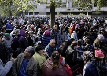 FILE - In this file photo taken Wednesday, Sept. 30, 2015, hundreds of migrants and refugees wait for Berlin's State Office of Health and Welfare,Lageso, the cities central registration point for asylum seekers in Berlin, Germany. Hundreds or more of Syrian refugees who want to return home are finding themselves trapped in Germany, often without their families. Some are going back illegally. (AP Photo/Markus Schreiber, file)