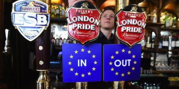 epa05259828 EU IN OUT bar coasters are pinned to ale taps at a pub in Westminster, London, Britain, 15 April 2016. The EU referendum campaign officially kicked off the same day with the 'Britain Stronger in Europe' and 'Vote Leave' to begin criss crossing the UK in order to get their message to the voters. Britain will vote on 23 June 2016 wether to remain in the EU or to leave.  EPA/ANDY RAIN