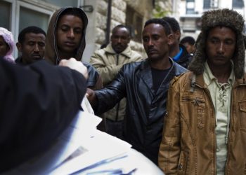 epa03588714 A group of Eritrean and Sudanese migrants wait to receive a temporary permit from an official, granting them permission to remain in Israel for the next four months, in Jerusalem, Israel, 17 Febraury 2013. The UN has claimed that Israel is coercing Eritrean refugees into signing 'voluntary' departure forms to return to Eritrea - where the UN says their lives would be in danger - or be sent to another country, a claim which Israel denies. Eritreans comprise some 60% of African migrants that have crossed into Israel. Up until June 2012, Eritrean and North Sudanese migrants who entered Israel illegally were released from prison after initially being detained at the border. The law has since been amended, giving the Israeli authorities the capacity to jail illegal African migrants and refugees for three years or more. The completion of the border fence with Egypt has also contributed to restricting the numbers of migrants attempting to cross into Israel.  EPA/JIM HOLLANDER