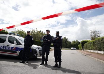 French police officers block the road leading to a crime scene the day after a knife-wielding attacker stabbed to death a senior police officer and his female companion Monday evening in Magnanville, west of Paris, France, Tuesday, June 14, 2016. French President Francois Hollande says that the stabbing attack that left two police officials dead was "incontestably a terrorist act." (AP Photo/Thibault Camus)