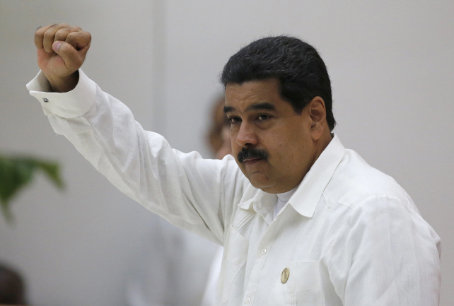 Venezuela´s President Nicolas Maduro salutes people attending signing ceremony of a cease-fire and rebel disarmament deal, in Havana, Cuba, Thursday, June 23, 2016. The deal moves Colombia closer to ending a 52-year war that has left more than 220,000 people dead. (AP Photo/Desmond Boylan)