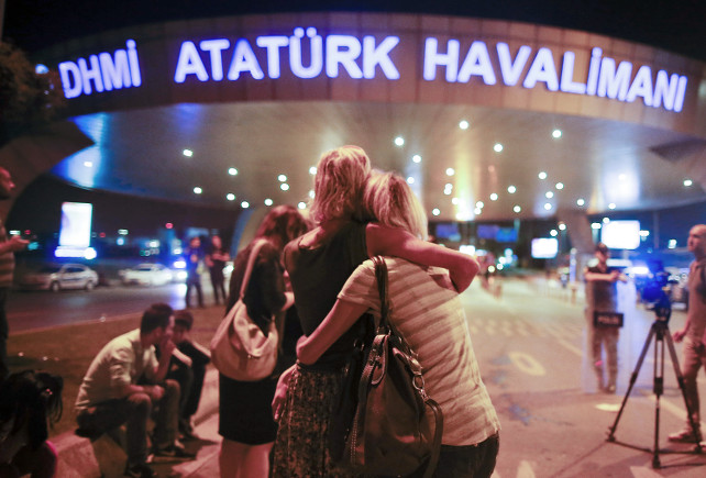 Passengers embrace each other on the entrance to Istanbul's Ataturk airport, early Wednesday, June 29, 2016 following its evacuation after a blast. Two explosions have rocked Istanbul's Ataturk airport Tuesday, killing several people and wounding scores of others, Turkey's justice minister and another official said. A Turkish official says two attackers have blown themselves up at the airport after police fire at them. Turkish authorities have banned distribution of images relating to the Ataturk airport attack within Turkey. (AP Photo/Emrah Gurel) TURKEY OUT