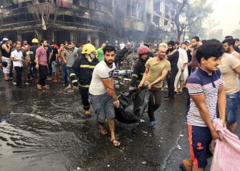 Iraqi firefighters and civilians evacuate bodies of victims killed from a car bomb at a commercial area in Karada neighborhood, Baghdad, Iraq, Sunday, July 3, 2016. Bombs went off early Sunday in two crowded commercial areas in Baghdad. (AP Photo/Khalid Mohammed)