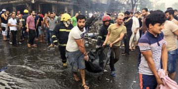Iraqi firefighters and civilians evacuate bodies of victims killed from a car bomb at a commercial area in Karada neighborhood, Baghdad, Iraq, Sunday, July 3, 2016. Bombs went off early Sunday in two crowded commercial areas in Baghdad. (AP Photo/Khalid Mohammed)
