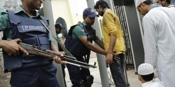 epa05425758 Security officials stand guard in front of the entrance of the National mosque and check people through archway metal detector during the Friday prayer in Dhaka 15 July 2016. Security has been beeped up after the terror attacks in Gulshan that left 20 hostages dead on 01 July and in another attack during the Eid prayer that killed four including two policemen in Sholakia, Kishoregonj on 07 July 2016.  EPA/ABIR ABDULLAH