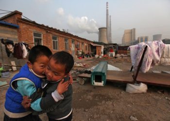 epa03017683 Chinese boys play in the courtyard of their home beside a power plant  in Beijing, China, 28 November 2011. Reports state that China, the world's largest emitter of greenhouse gases, is rallying key allies to push developed nations to agree to binding targets for reducing carbon emissions ahead of climate change talks in Durban even as it maintains that developing countries continue to be exempt as these would hamper efforts to alleviate poverty.  EPA/HOW HWEE YOUNG