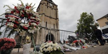 A wreath of flowers from Muslim of France Associations is placed with flowers next to the church where an hostage taking left a priest dead the day before in Saint-Etienne-du-Rouvray, Normandy, France, Wednesday, July 27, 2016. The Islamic State group crossed a new threshold Tuesday in its war against the West, as two of its followers targeted a church in Normandy, slitting the throat of an elderly priest celebrating Mass and using hostages as human shields before being shot by police. (AP Photo/Francois Mori)