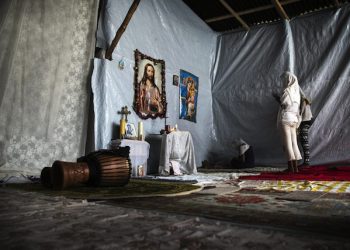 epa04875965 Three migrant women from Eritrea pray in a small church they have built at the makeshift migrant camp the 'Jungle' on the outskirts of Calais, France, 07 August 2015. More than 3,000 migrants live in the camp according to associations and non-governmental organizations (NGOs).  EPA/ETIENNE LAURENT