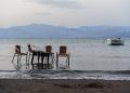 epa04868314 Flooded cafe chairs and table in the Ionian sea at the beach of Rhoda, Corfu, Greece, 31 July 2015.  EPA/FILIP SINGER